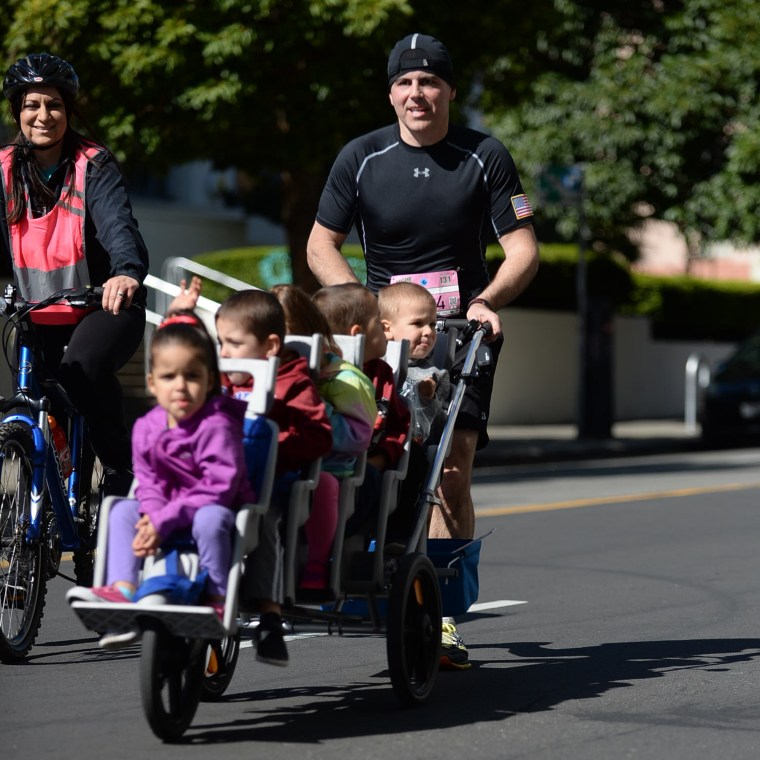 Chad Kempel's wife, Amy, rode a bike alongside her husband and their quintuplets.