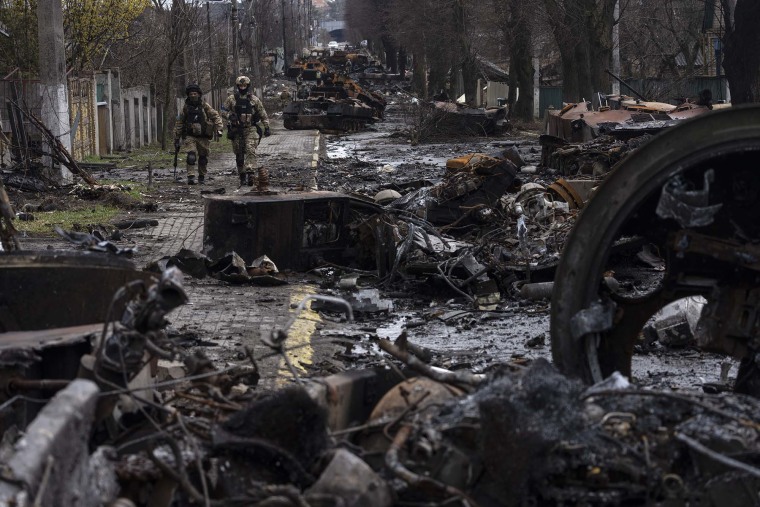 Soldados caminan entre tanques rusos destruidos en Bucha, en las afueras de Kiev, Ucrania, el domingo 3 de abril de 2022.