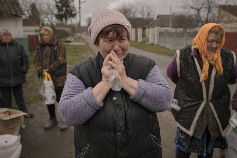 Una mujer llora mientras espera junto con otras personas la distribución de productos alimenticios en la aldea de Motyzhyn, Ucrania, que hasta hace poco estuvo bajo el control del ejército ruso, el domingo 3 de abril de 2022.