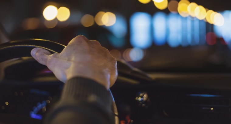Hand on steering wheel at night