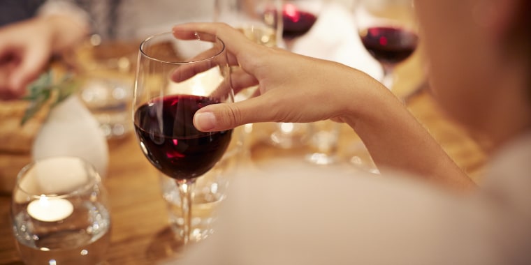 Close-up of female holding glass with redwine
