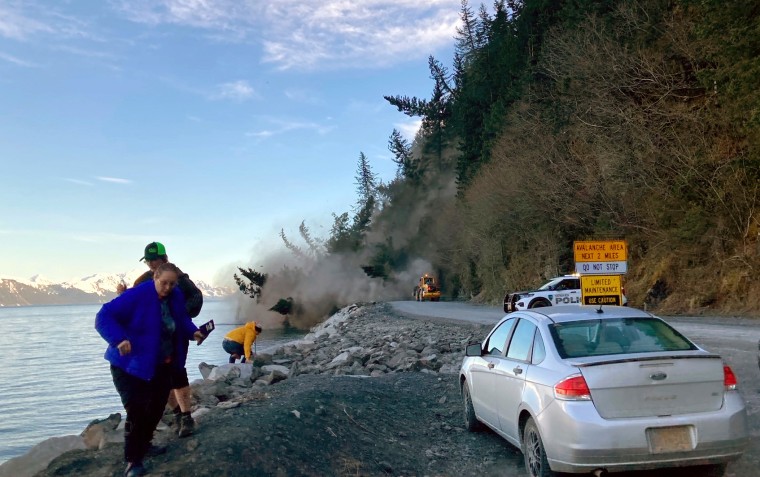People run from a landslide just outside the downtown area of Seward, Alaska, May 7, 2022. There were no reported injuries in the landslide, which the city estimates could take up to two weeks to clear. (Josh Gray via AP)