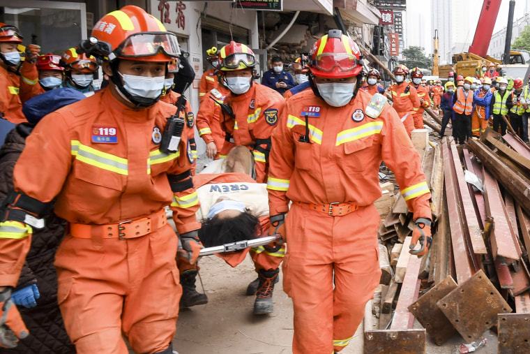Rescuers evacuate a woman pulled alive from a collapsed building in Changsha, central China's Hunan Province, on May 1, 2022.