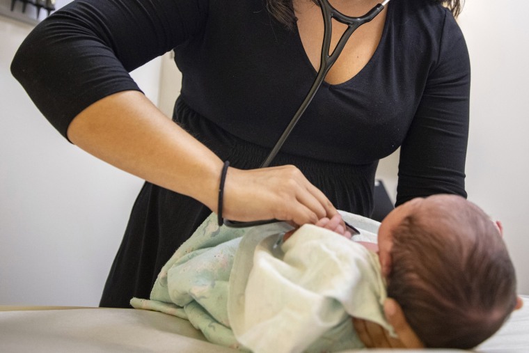 A pediatrician examines a newborn baby in her clinic in Chicago on Aug. 13, 2019.