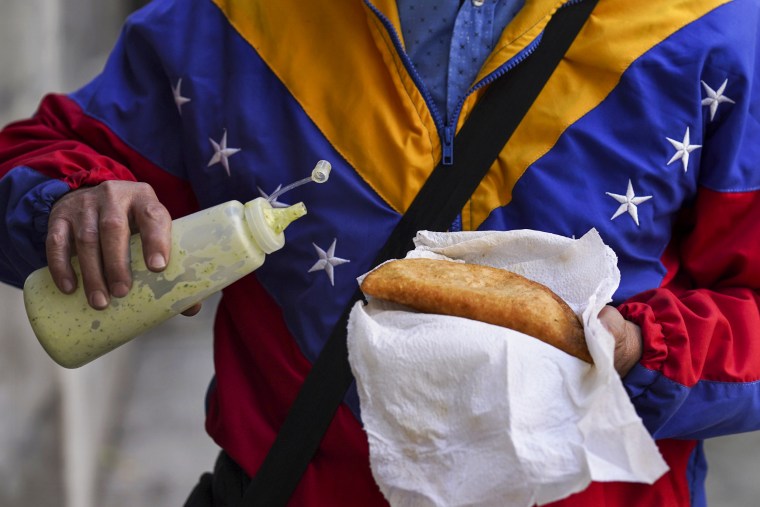Venezuelan migrant Nelson Banda sells empanadas in front of the Venezuelan embassy in Mexico City on April 20, 2022.