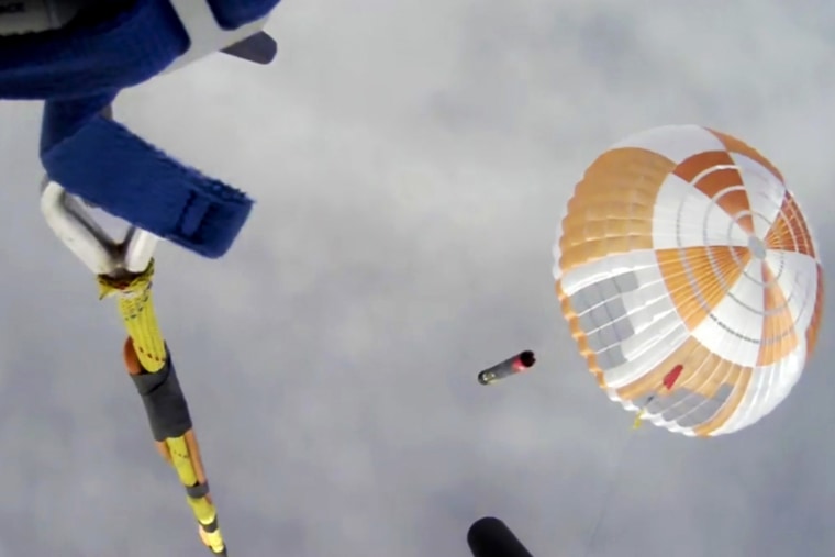 A helicopter hovers above as it attempts to capture Electron's first stage in mid-air by helicopter above New Zealand on Tuesday. 