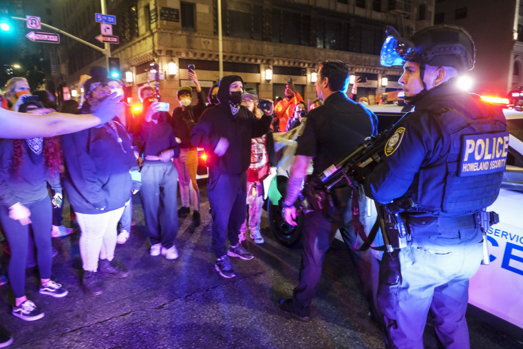 Demonstrators confront police officers