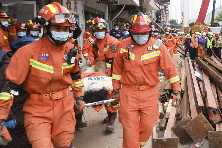 Rescuers evacuate a woman pulled alive from a collapsed building in Changsha, China, on Sunday.
