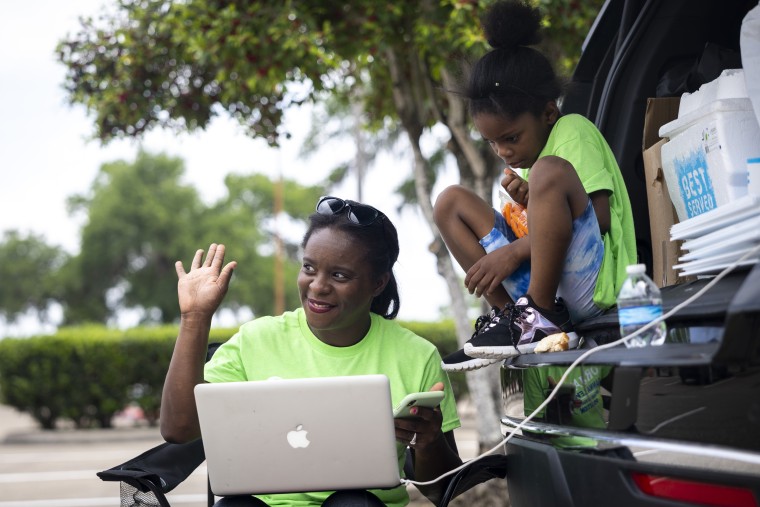 School board trustee hopeful Orjanel Lewis waves to supporters as she teaches the last legal writing course of the semester while campaigning on Election Day on May 7, 2022, in Ft. Bend County, Texas.