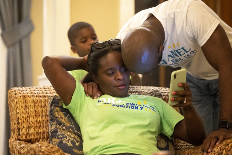 School board trustee hopeful Orjanel Lewis gets a hug from her husband, Marcus, as she looks for refreshed numbers  at her results watch party on May 7, 2022, in Fresno, Texas.