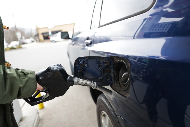 A woman pumps gas into her car