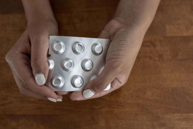 A woman who self-managed her abortion holds a packet of misoprostol.