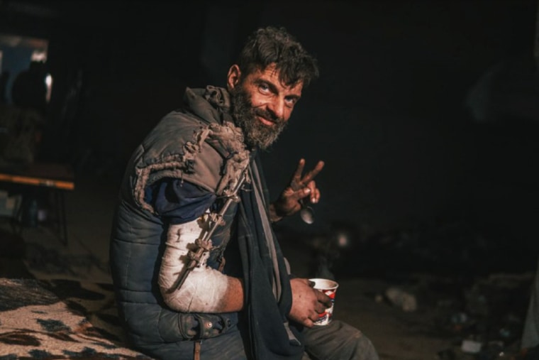 A wounded Ukrainian soldier sits below the besieged Azovstal steel plant in Mariupol on May 10, 2022.