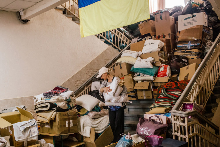 A volunteer carries blankets donated at a refugee center in Odesa, Ukraine on May 3, 2022.