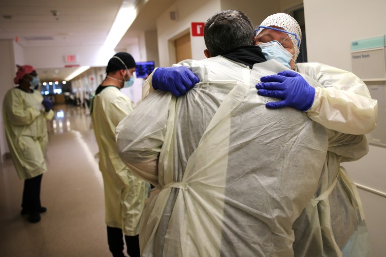 Chaplain Kevin Deegan hugs registered nurse Connie Carrillo