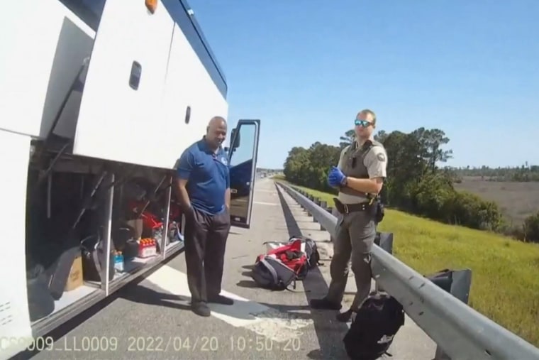 A police offer, right, stands with the bus driver of the women’s lacrosse team for Delaware State University.