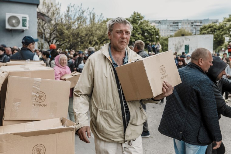A local resident receives humanitarian aid in Kharkiv, amid