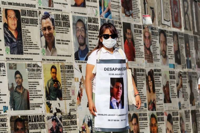 The mother of Osvaldo Javier Hernandez, who is missing, holds a sign with his photo during a demonstration to demand the government find him and other missing people at the Glorieta de Los Desaparecidos, Roundabout of the Disappeared, in Guadalajara, Jalisco state, Mexico, on May 10, 2022.
