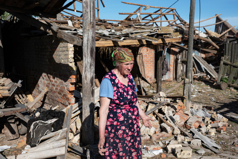 A woman observes her heavily damaged property