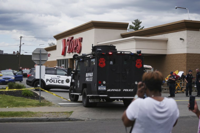 Image: A crowd gathers as law enforcement investigates the scene of a mass shooting at a Tops supermarket in Buffalo, N.Y., on Saturday.