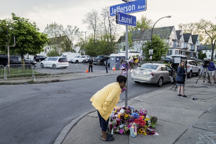 A woman contributes to a shrine situated on Jefferson Avenue in Buffalo, N.Y. on May 15, 2022.