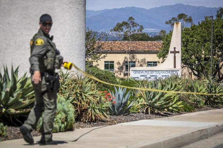 An Orange County Sheriff's officer places police tape around the exterior of the Geneva Presbyterian Church after a person opened fire during a church service, in Laguna Woods, Calif., on May 15, 2022.