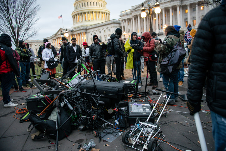 Demonstrators stand next to destroyed broadcast equipment belonging to journalists outside the U.S. Capitol building during a protest on Jan. 6, 2021.