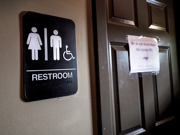 A unisex sign and the "We Are Not This" slogan are outside a bathroom at Bull McCabes Irish Pub on May 10, 2016 in Durham, N.C.