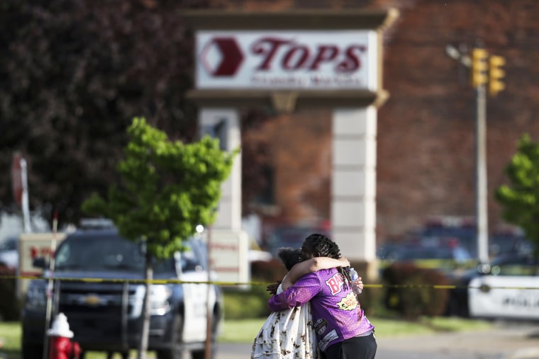 People hug outside the scene after a shooting at a Tops Friendly Market