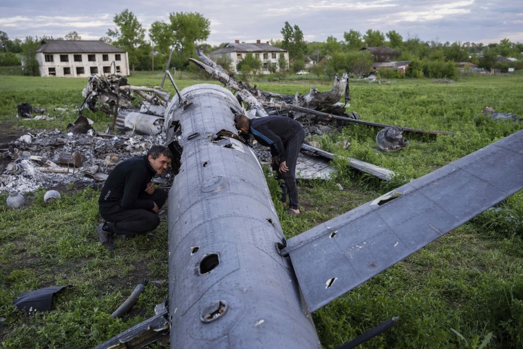 Local residents check the remains of a destroyed Russian helicopter in the village of Malaya Rohan, Kharkiv region, Ukraine, on May 16, 2022. 