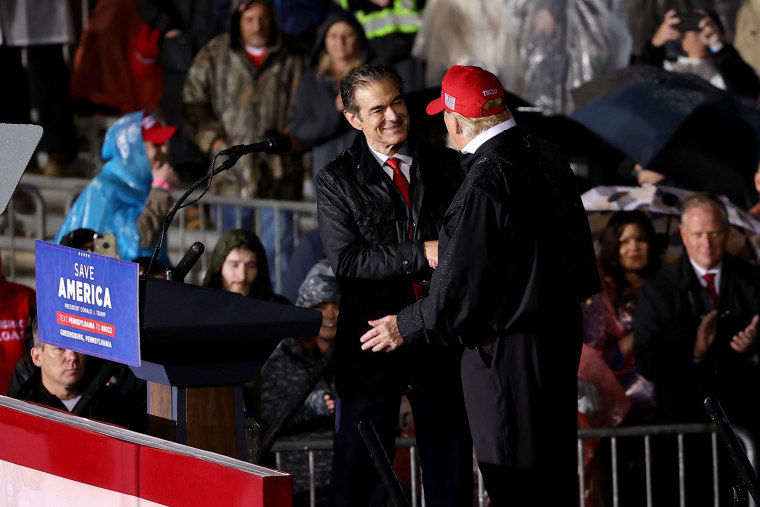 Image: Senate candidate Mehmet Oz and former President Donald Trump shake hands at a rally in Greensburg, Pa.,  on May 6, 2022.