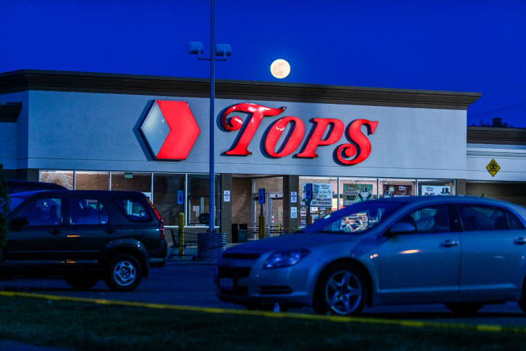 The moon rises behind the Tops Friendly Market on Jefferson Avenue in Buffalo, N.Y., on May 15, 2022.