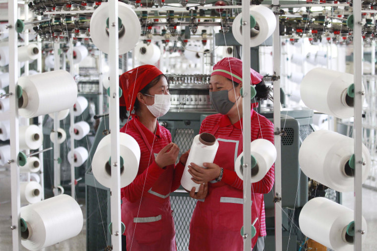 Des employés de Songyo Knitwear Factory portant des masques faciaux travaillent pour produire des articles tricotés dans le district de Songyo à Pyongyang, le 18 mai 2022.