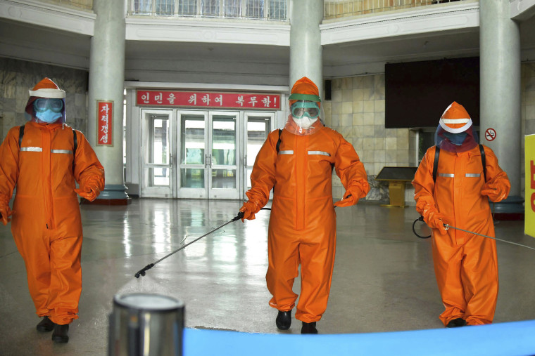 Government staff disinfect the floor of Pyongyang station on Tuesday to try to curb the spread of Covid in North Korea's capital.