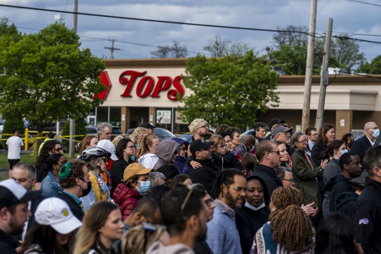 People attend a vigil across the street from Tops Friendly Market on May 17, 2022, in Buffalo, N.Y.