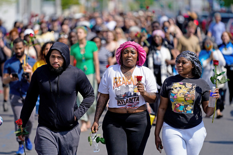 People march to the scene of the shooting at a Tops Friendly Market