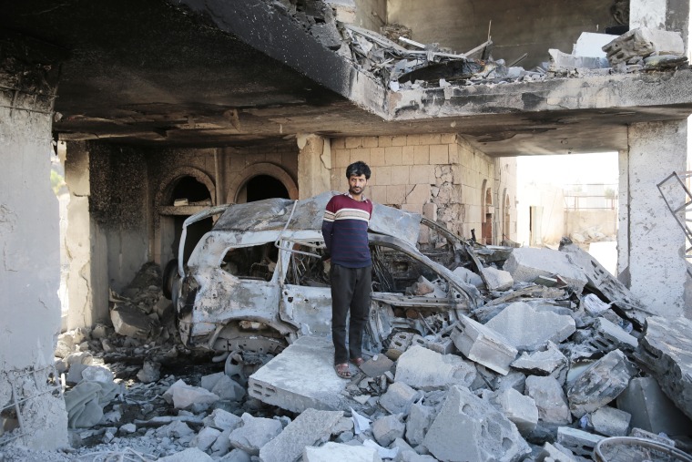 A Yemeni man stands on the rubble a damaged building at the site of a Saudi-led air strike in Sanaa on Jan. 18, 2022.