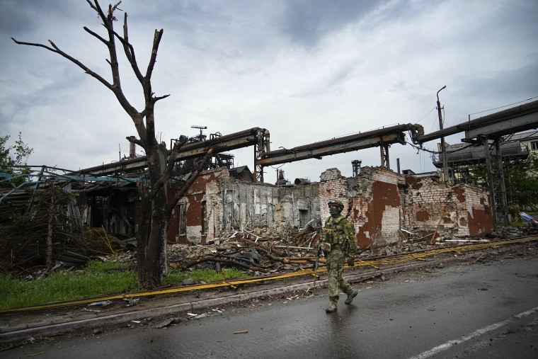 A Russian soldier patrols a destroyed part of the Illich Iron & Steel Works in Mariupol.