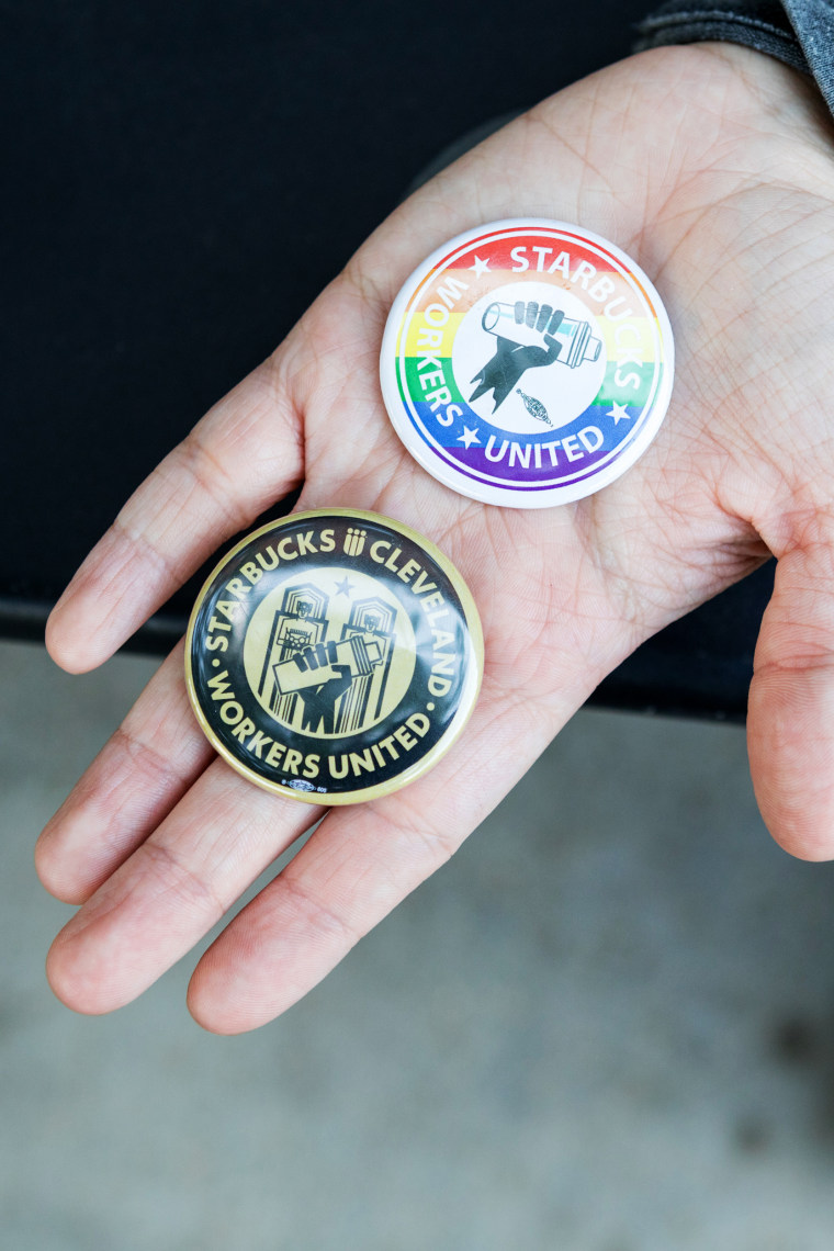 Starbucks coffee supervisor Maddie Vanhook holds Starbucks Workers United pins, in Cleveland, on May 19.