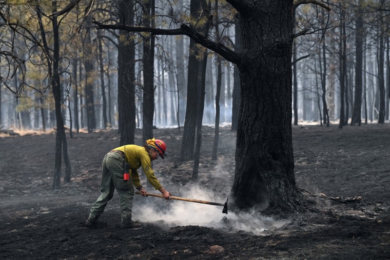 MORA, NM- MAY 13: A firefighter works on putting out a hotspot from a wildfire on Friday May 13, 2022 in Mora, NM. The Calf Canyon and Hermits Peak fires have been burning in the region. The Hermits Peak fire started as a prescribed burn.