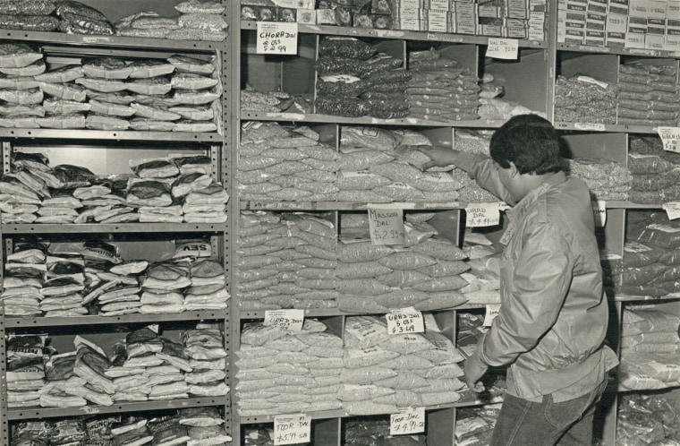 Syn właściciela zaopatruje półki w sklepie Patel Brothers przy 2542 West Devon Avenue w Chicago, listopad 1984 r.