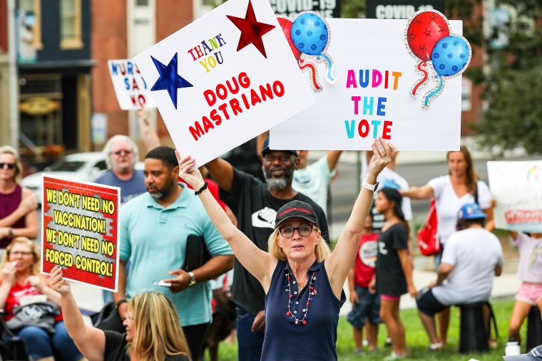 A protester holds placards during the anti-vaccine, anti-