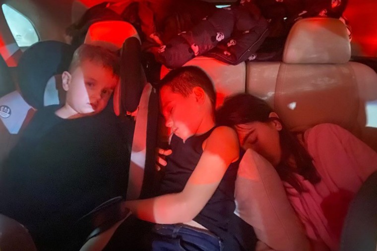 Les réfugiés ukrainiens Danylo, 3 ans, Lev, 7 ans, et Vasilisa Halytska, 11 ans, ont dormi dans la voiture pendant plusieurs jours, alors que leur famille tentait de sortir d'Ukraine.