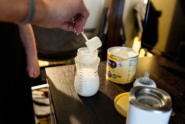 Lisa Davis prépare une bouteille de lait maternisé pour son fils de 14 mois, Jack, dans une chambre d'hôtel à Austin.