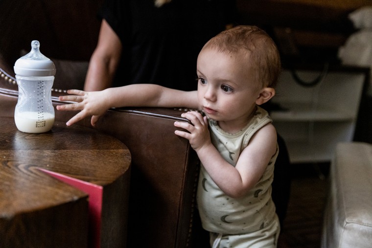 Jack, Lisa Davis' 14-month-old-son, reaches for a bottle of formula at a hotel room in Austin.