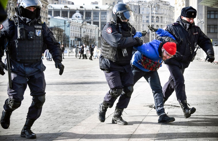 Police officers detain a man during a protest against Russia's invasion of Ukraine in central Moscow on March 13, 2022.