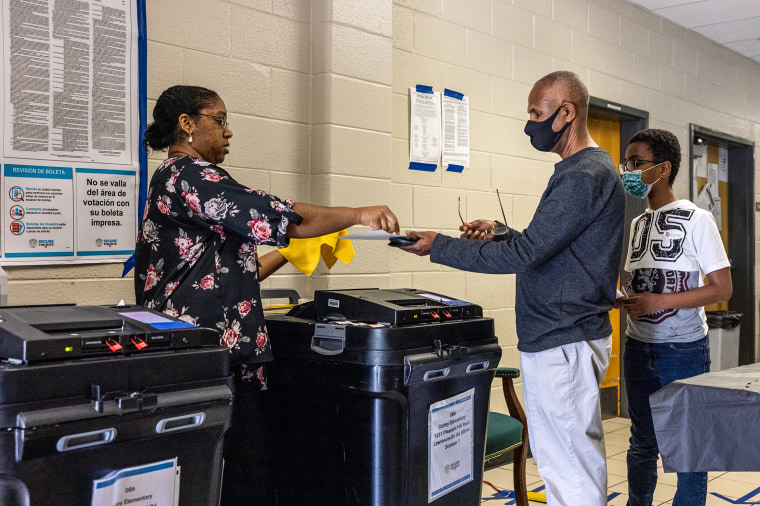 A poll worker assists a voter Tuesday at Corley Elementary School in Buford in Gwinnett County, Ga.