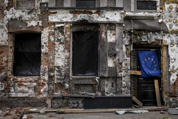 A heavily damaged facade of a building adjacent to the Faculty of Economics and Business School of the V.N. Karazin Kharkiv National University features the flag of the European Union on May 18, 2022, in Kharkiv, Ukraine.