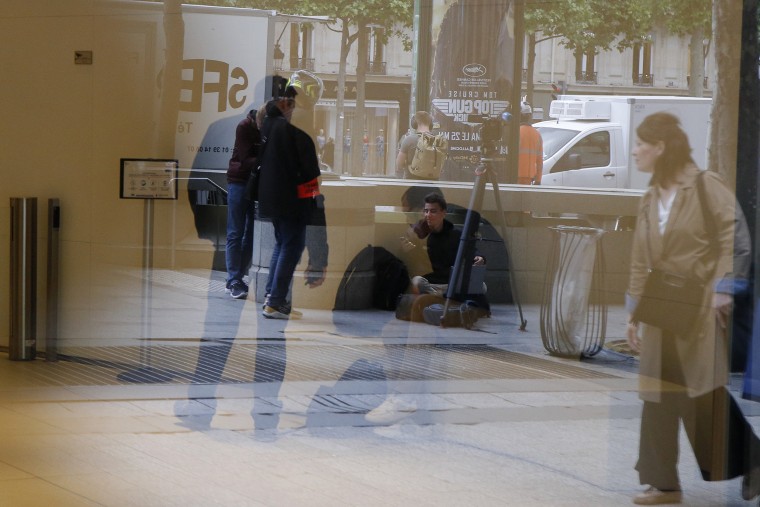 Image: A police officer, with red armband, stands in the building hosting McKinsey & Company France, on May 24, 2022 in Paris.