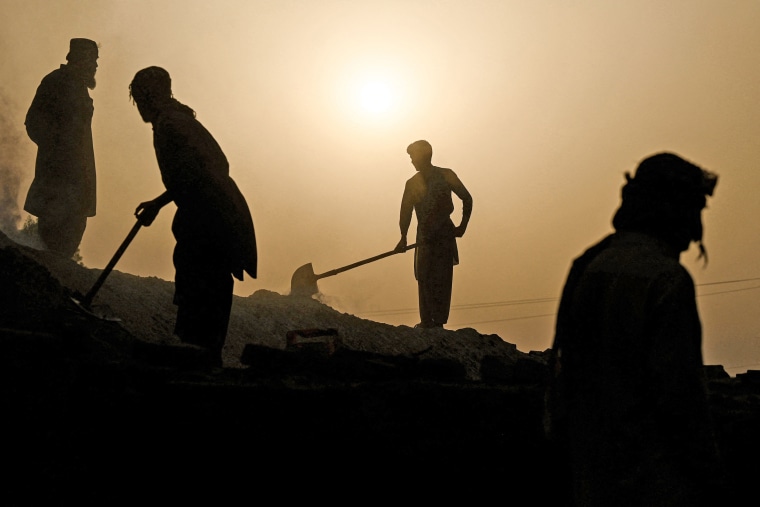 Laborers work at a brick kiln factory during a heatwave in Jacobabad, Pakistan, on May 12, 2022.